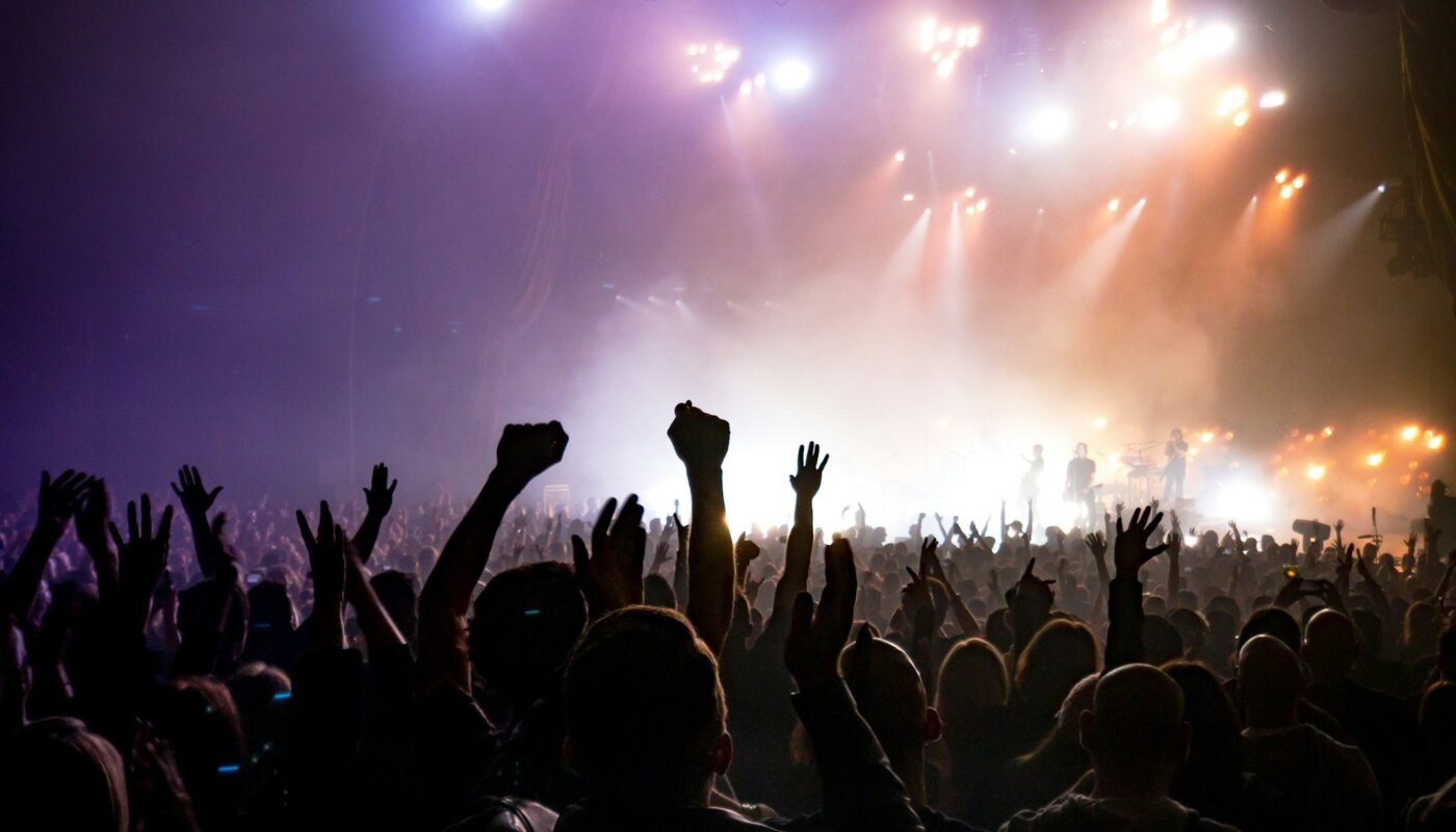 Vehicles waiting near a concert venue at night